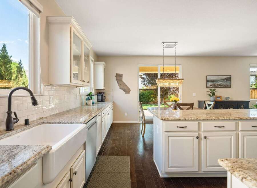 Experience the heart of this home with a spacious kitchen featuring a large farmhouse sink and granite countertops.