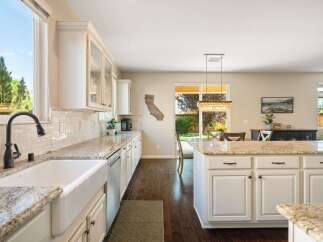 Experience the heart of this home with a spacious kitchen featuring a large farmhouse sink and granite countertops.