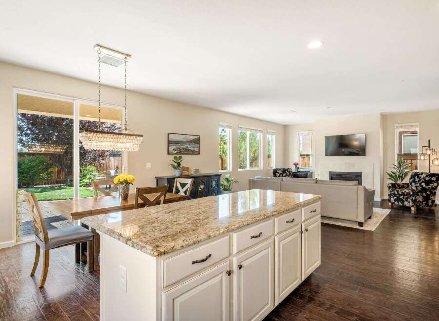 Experience open-concept living in this stunning home, featuring a spacious kitchen island with granite countertops perfect for entertaining.
