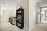This hallway features a dark wood bookshelf filled with books, providing ample storage and a touch of classic charm.