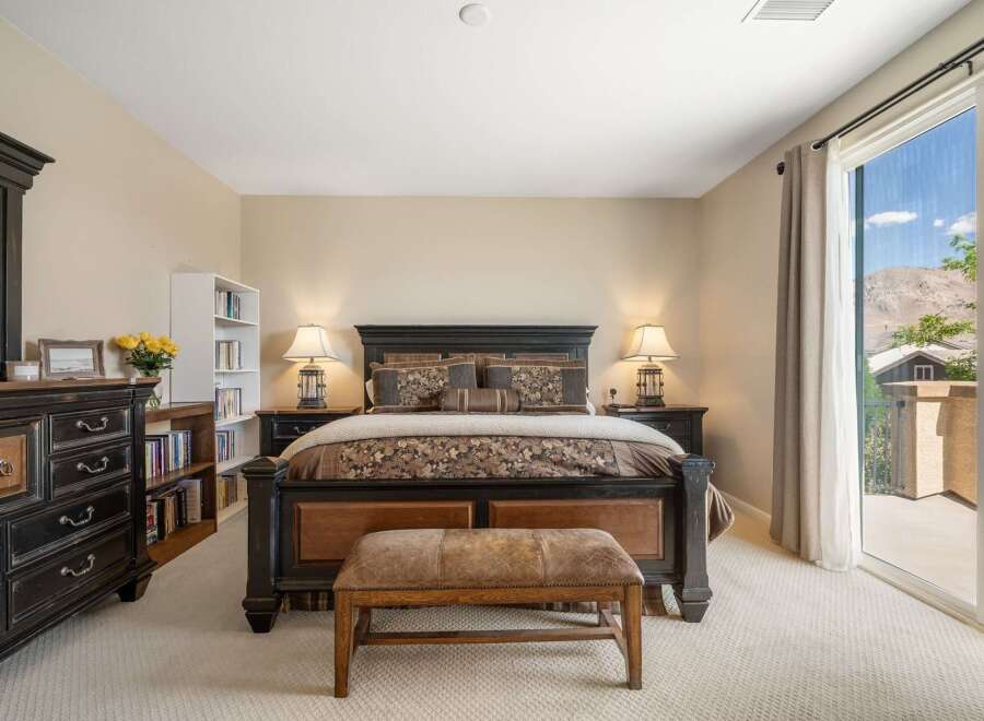 Experience luxury and comfort in this master bedroom, featuring a grand king-size bed with a dark wood frame and elegant patterned bedding.