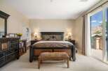 Experience luxury and comfort in this master bedroom, featuring a grand king-size bed with a dark wood frame and elegant patterned bedding.
