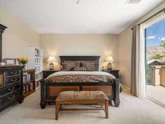 Experience luxury and comfort in this master bedroom, featuring a grand king-size bed with a dark wood frame and elegant patterned bedding.