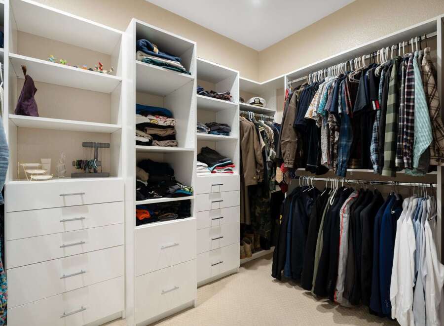 Discover organized luxury in this spacious walk-in closet, featuring ample shelving and drawers for all your clothing and accessories.