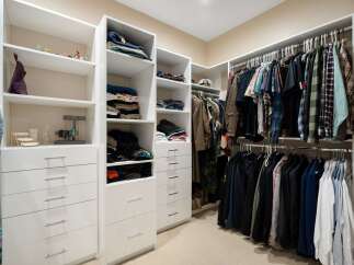 Discover organized luxury in this spacious walk-in closet, featuring ample shelving and drawers for all your clothing and accessories.