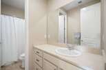 This bright and clean bathroom features a spacious vanity with ample counter space and storage, perfect for organizing your essentials.