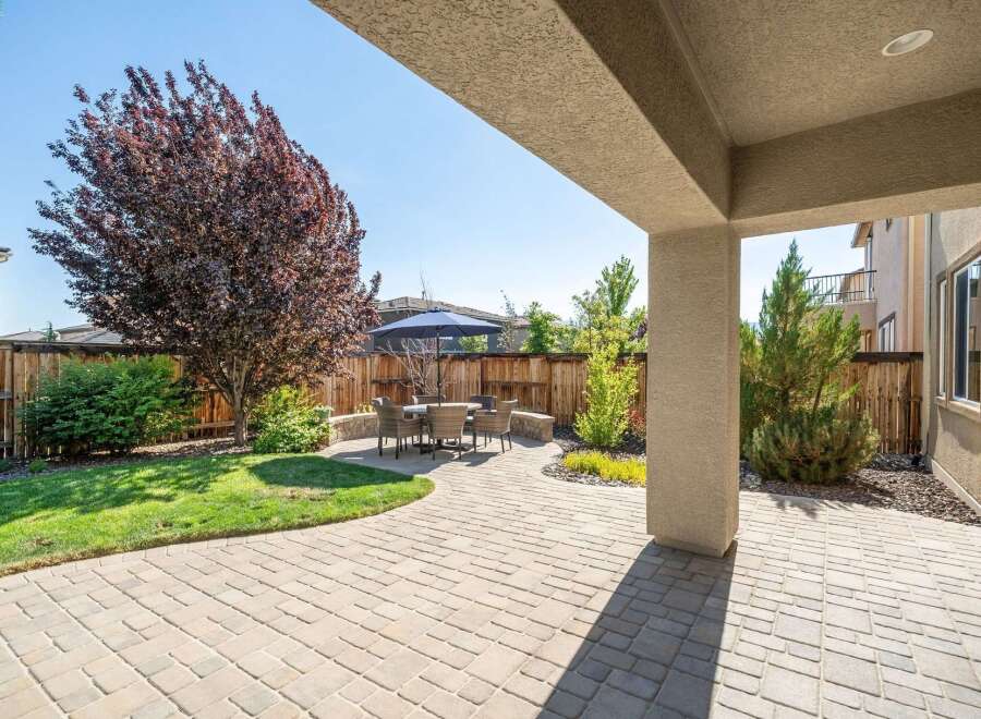 Enjoy outdoor living in this beautifully landscaped backyard featuring a spacious paver patio perfect for entertaining.