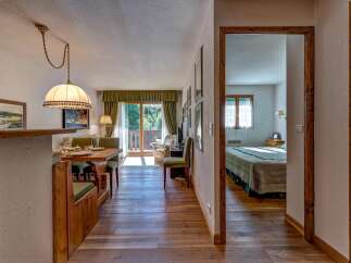 Experience cozy living in this charming apartment featuring a dining area with a built-in bench and a wooden table, perfect for intimate meals.