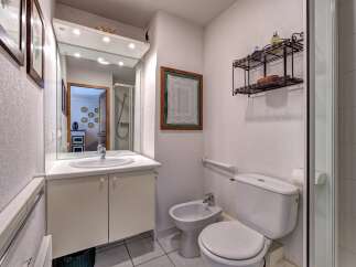 This charming bathroom features a modern vanity with ample storage, a sleek sink, and a large mirror.