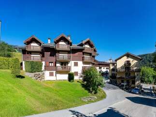 Experience alpine living in this charming property featuring traditional wooden architecture and multiple balconies offering scenic views.