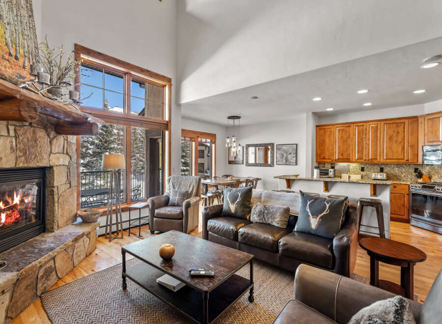 Experience rustic luxury in this mountain retreat featuring a grand stone fireplace and soaring vaulted ceilings.