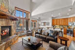 Experience rustic luxury in this mountain retreat featuring a grand stone fireplace and soaring vaulted ceilings.
