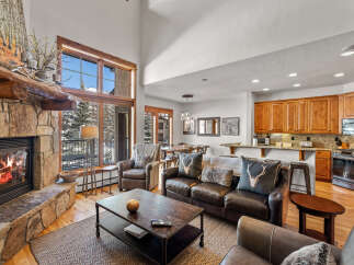 Experience rustic luxury in this mountain retreat featuring a grand stone fireplace and soaring vaulted ceilings.