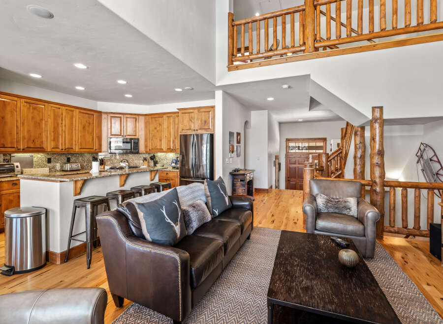 Experience rustic charm in this spacious living area, featuring a gourmet kitchen with rich wood cabinetry and granite countertops, perfect for entertaining.