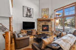 Experience rustic charm and cozy evenings in this mountain living room, featuring a grand stone fireplace and comfortable leather seating.