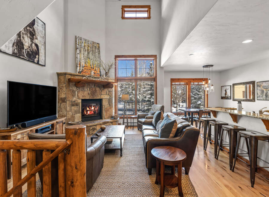 Experience rustic luxury in this stunning mountain lodge living room, featuring a grand stone fireplace and soaring vaulted ceilings.