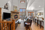 Experience rustic luxury in this stunning mountain lodge living room, featuring a grand stone fireplace and soaring vaulted ceilings.
