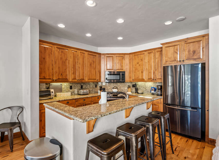 This spacious kitchen boasts beautiful custom wood cabinetry and granite countertops, offering ample storage and a timeless aesthetic.