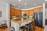 This spacious kitchen boasts beautiful custom wood cabinetry and granite countertops, offering ample storage and a timeless aesthetic.