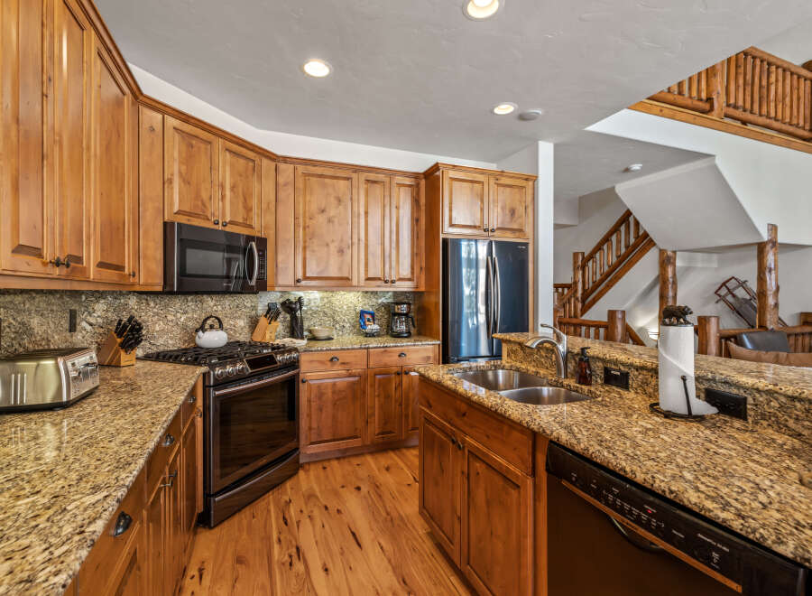Experience rustic charm in this spacious kitchen featuring warm, knotty pine cabinetry and stunning granite countertops.