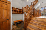 Experience rustic charm with this stunning log staircase and entryway, featuring a convenient wooden bench and ample shelving for storage.