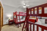 This charming bedroom features two sets of vibrant red bunk beds, perfect for accommodating multiple guests.