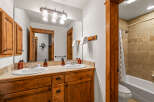This charming bathroom features a double vanity with wooden cabinetry and granite countertops, perfect for shared living.