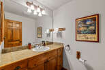 This charming bathroom features a rustic wooden vanity with a tiled countertop and a white undermount sink.