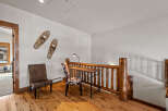 This charming loft area features a rustic wooden desk and chairs, perfect for a home office or study nook.