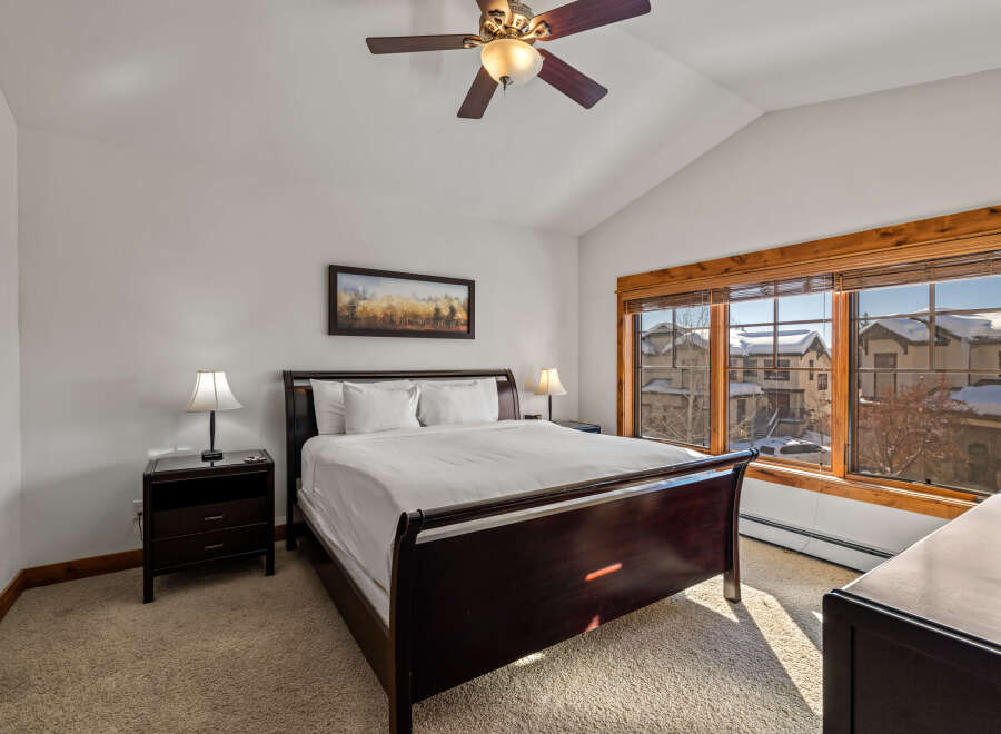 Experience comfort and style in this inviting bedroom, featuring a plush king-sized bed and elegant dark wood furniture.