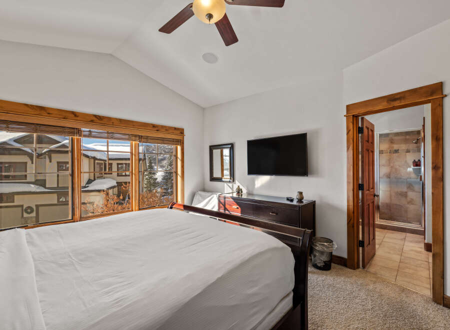 Experience mountain living in this charming bedroom featuring a spacious king-size bed and a private ensuite bathroom.