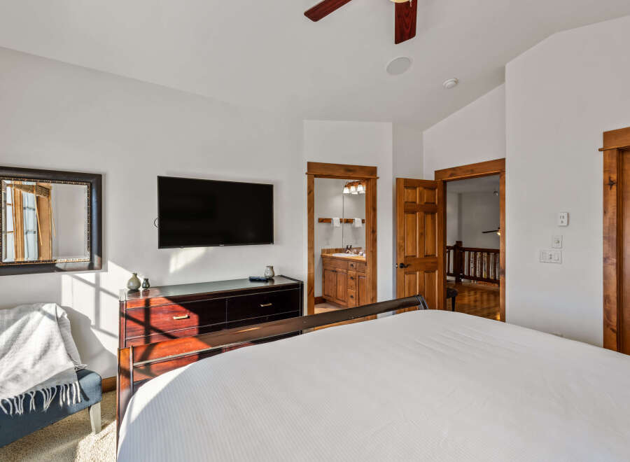 This inviting bedroom features a spacious king-sized bed with crisp white linens, perfect for a restful night's sleep.