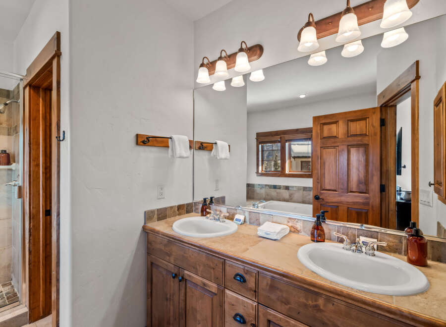 This luxurious bathroom features a spacious double vanity with ample counter space and elegant wooden cabinetry.