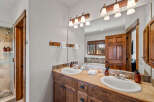 This luxurious bathroom features a spacious double vanity with ample counter space and elegant wooden cabinetry.