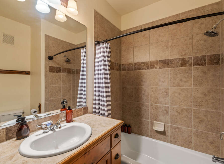 This bathroom features a spacious vanity with a double sink and ample counter space, perfect for morning routines.