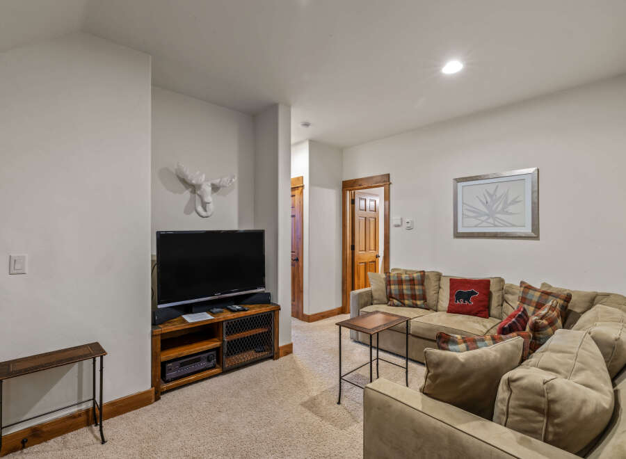 Cozy living room featuring a plush sectional sofa adorned with plaid and bear-themed throw pillows.