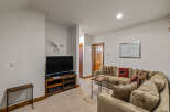 Cozy living room featuring a plush sectional sofa adorned with plaid and bear-themed throw pillows.