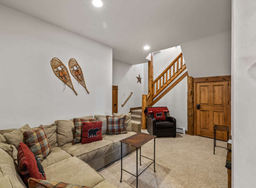 Cozy living room featuring a large sectional sofa adorned with plaid and bear-themed pillows, perfect for relaxation.