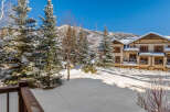 Experience the ultimate winter wonderland with this stunning property nestled amidst snow-covered pine trees and majestic mountains.
