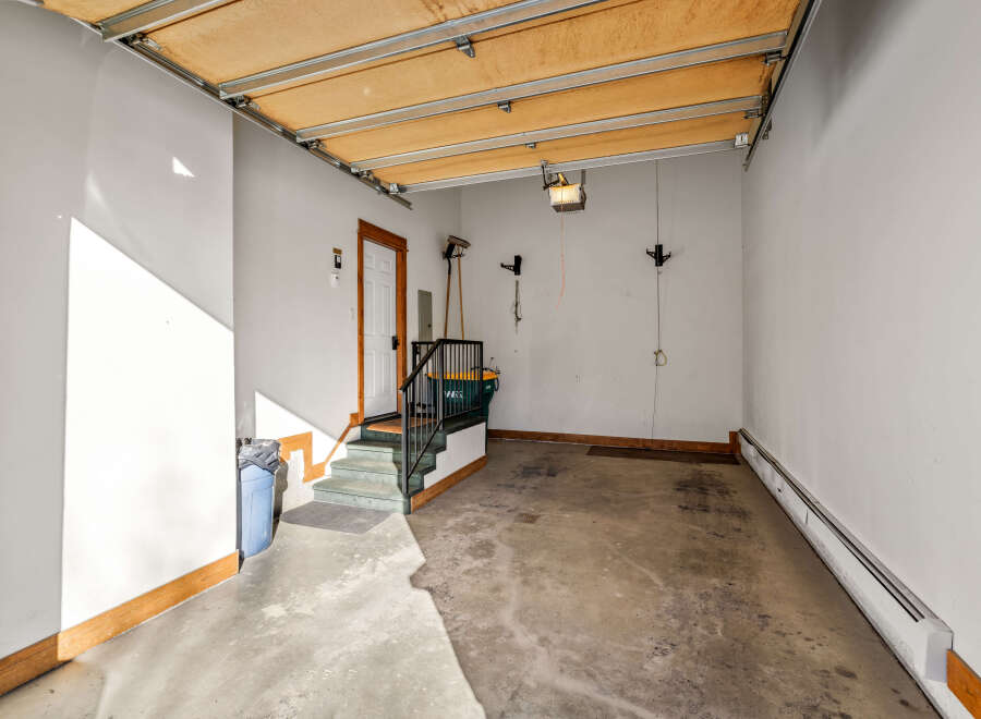 This spacious garage offers ample storage and convenience with its direct access to the interior via a well-lit staircase.