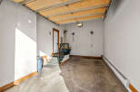 This spacious garage offers ample storage and convenience with its direct access to the interior via a well-lit staircase.