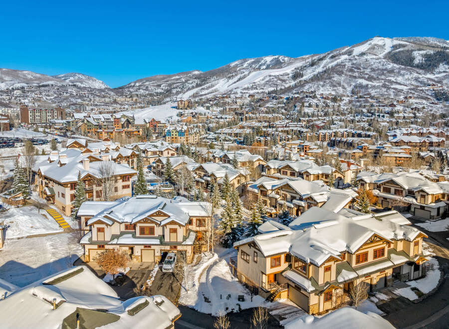 Experience luxury mountain living in this stunning ski resort town, featuring charming townhomes blanketed in fresh snow.