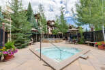 Enjoy a relaxing dip in the inviting hot tub, surrounded by lush greenery and mountain views.
