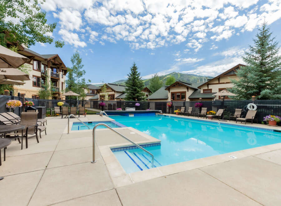 Enjoy a refreshing dip in this stunning outdoor swimming pool, complete with a relaxing hot tub and ample lounge seating.