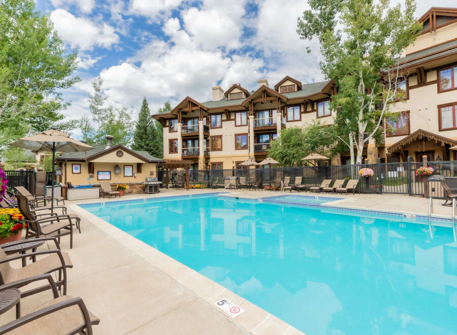 Enjoy a refreshing dip in the sparkling blue pool, surrounded by comfortable lounge chairs perfect for soaking up the sun.