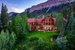 Experience luxury mountain living in this stunning lodge-style home, nestled against a majestic cliff face.