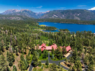 Experience luxury living in this stunning mountain estate, nestled amidst a lush pine forest with breathtaking views of a serene lake and majestic peaks.