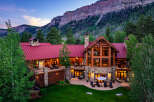 Experience luxury mountain living in this stunning lodge-style home, nestled against a majestic cliff face.