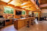 Experience ultimate entertainment in this stunning custom-built bar and lounge area, featuring a beautiful wooden bar with a built-in tap, a large television, and ample seating.