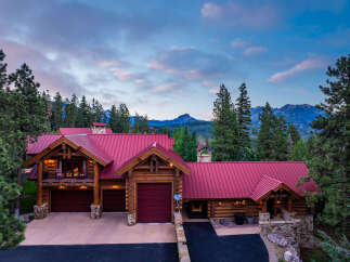 Experience the ultimate mountain retreat in this stunning log home, nestled amidst towering pine trees and offering breathtaking views of distant peaks.